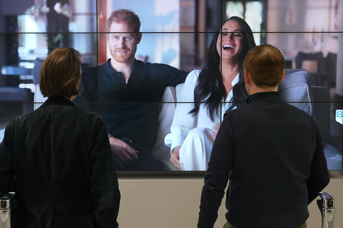 Office workers in London, watch the Duke and Duchess of Sussex's controversial documentary being aired on Netflix Thursday, Dec. 8, 2022.