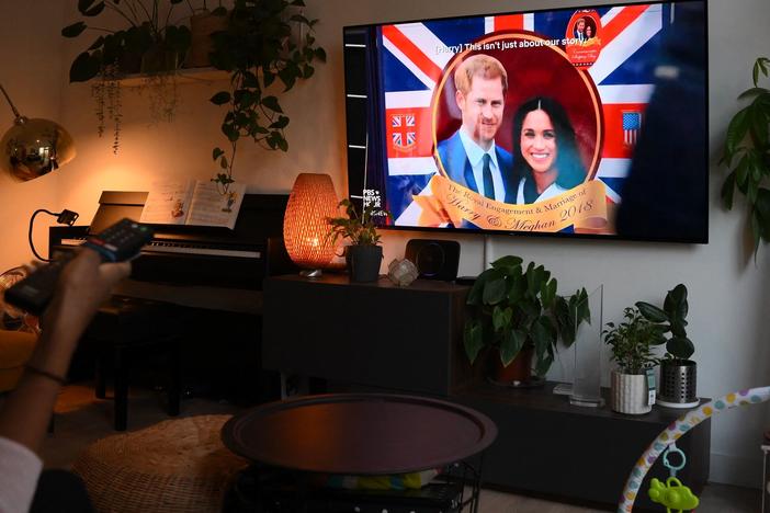 A woman watches an episode of the newly released Netflix docuseries <em>Harry & Meghan,</em> about Britain's Prince Harry, Duke of Sussex, and Britain's Meghan, Duchess of Sussex, in London on Thursday.