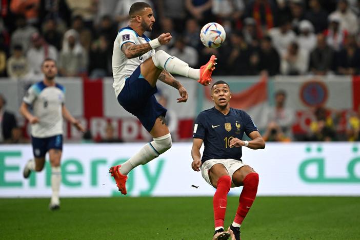 France forward Kylian Mbappe (#10) fights for the ball with England defender Kyle Walker during the World Cup quarterfinal match between England and France at the Al-Bayt Stadium in Al Khor, Qatar on December 10, 2022.