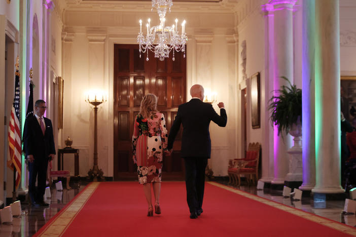 President Biden and first lady Jill Biden walk through the Cross Hall of the White House lit with rainbow colors following an event commemorating LGBTQ+ Pride Month in the East Room last year.