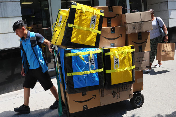 An Amazon worker pulls a cart of packages for delivery in New York City in July. A promotion that enabled shoppers to tip workers last week maxed out in less than 48 hours.