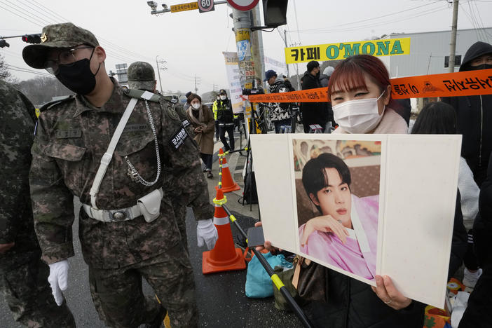 A fan waits for K-pop band BTS's member Jin to arrive before he enters the army to serve near an army training center in Yeoncheon, South Korea, on Tuesday.