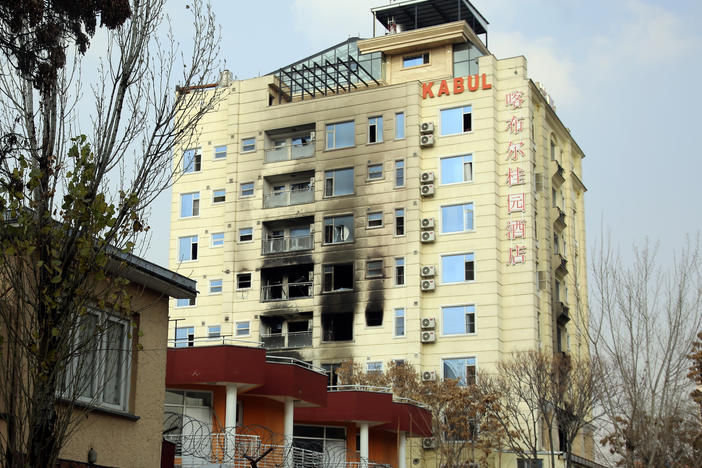 A hotel building sits charred after an attack in Kabul, Afghanistan, Tuesday, Dec. 13, 2022. The militant Islamic State group has claimed responsibility for a coordinated attack on the Chinese-owned hotel in Afghanistan's capital that left three assailants dead and at least two of the hotel guests injured as they tried to escape by jumping out from a window.
