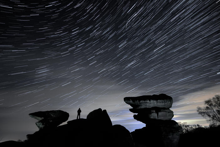 A man watches a meteor during the Geminid meteor shower over Brimham Rocks in North Yorkshire.