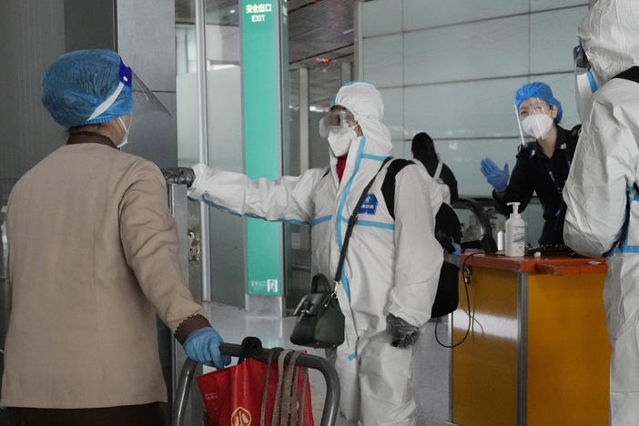 Passengers in protective gear are directed to a flight at a Capital airport terminal in Beijing, Tuesday, Dec. 13, 2022.