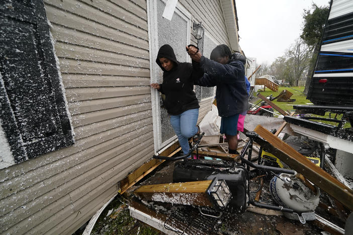 People help each other through the rubble after a tornado tore through the area in Killona, La., about 30 miles west of New Orleans in St. James Parish, Wednesday, Dec. 14, 2022.