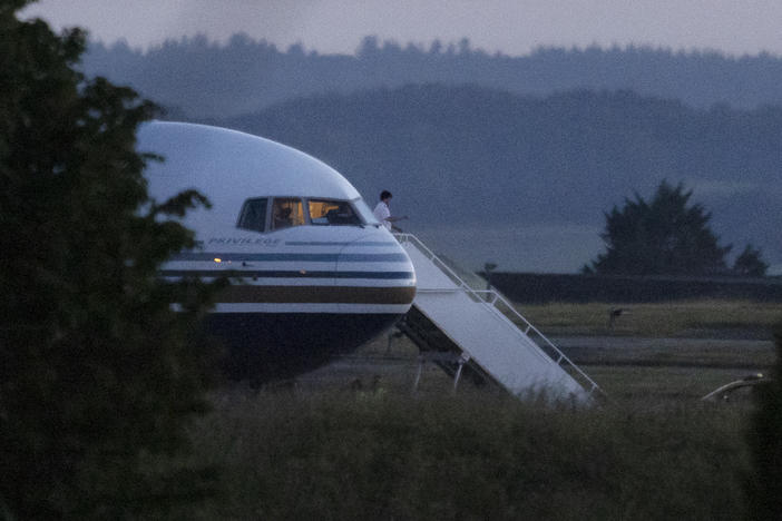 A pilot gestures from the grounded EC-LZO Boeing 767 flight, initially meant to deport Rwandan asylum-seekers, at Boscombe Down Air Base in Boscombe Down, England, on June 14. The flight taking asylum-seekers from the U.K. to Rwanda was grounded at the last minute, after the intervention of the European Court of Human Rights.