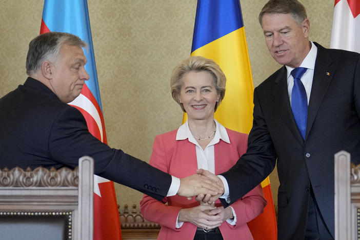 Hungarian Prime Minister Viktor Orban shakes hands with Romanian President Klaus Iohannis as European Commission President Ursula von der Leyen smiles at the Cotroceni presidential palace in Bucharest, Romania, Saturday, Dec. 17, 2022.