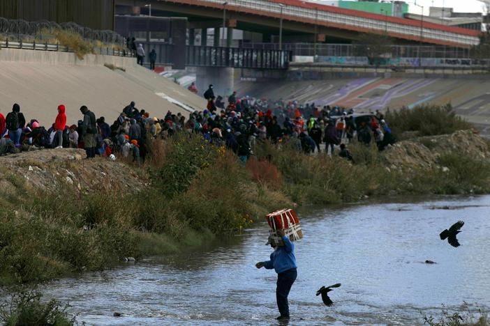 Migrants walk across the Rio Grande to surrender to US Border Patrol agents in El Paso, Texas, as seen from Ciudad Juarez, Chihuahua state, Mexico, on December 13, 2022. (Photo by Herika Martinez / AFP)