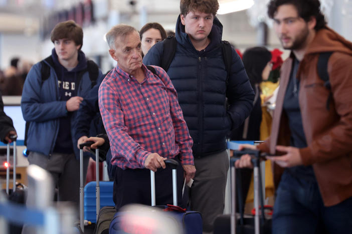 Travelers arrive for flights at O'Hare International Airport in Chicago on Dec. 16.