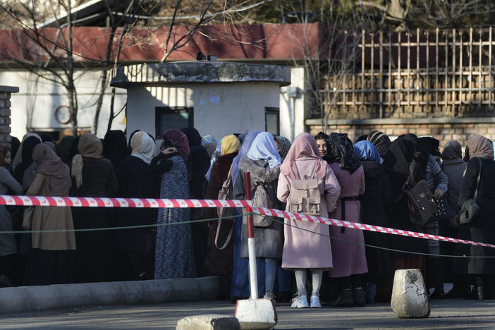 Afghan students queue at one of Kabul University's gates in Kabul, Afghanistan, on Feb. 26. Women are banned from private and public universities in Afghanistan until further notice, a Taliban government spokesman said Tuesday.