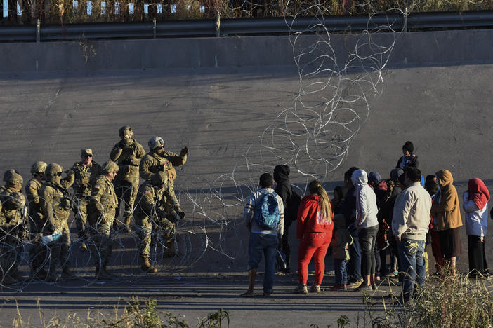 U.S. military stop migrants from crossing into El Paso, Texas, seen from Ciudad Juarez, Mexico, Tuesday, Dec. 20, 2022. The U.S. Supreme Court issued a temporary order to keep pandemic-era limits on asylum-seekers in place, though it could be brief, as conservative-leaning states push to maintain a measure that allows officials to expel many but not all asylum-seekers.