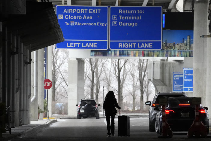 An airline passenger walks to her ride share vehicle after arriving at Chicago's Midway Airport just days before a major winter storm Tuesday, Dec. 20, 2022, in Chicago.