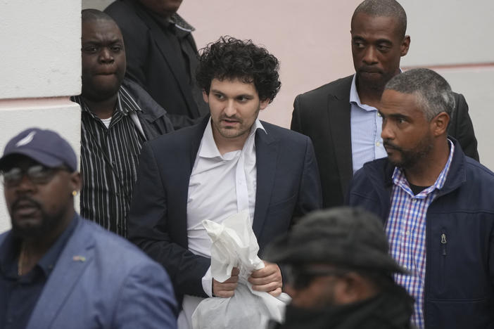 FTX founder Sam Bankman-Fried, center, is escorted from the Magistrate Court in Nassau, Bahamas, Wednesday, Dec. 21, after agreeing to be extradited to the U.S.