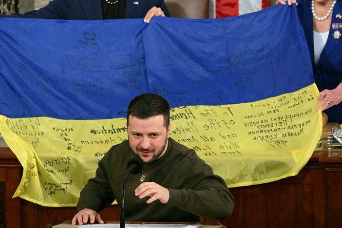 House Speaker Nancy Pelosi and Vice President Harris hold up a Ukrainian flag while Ukrainian President Volodymyr Zelenskyy speaks to Congress on Wednesday evening.