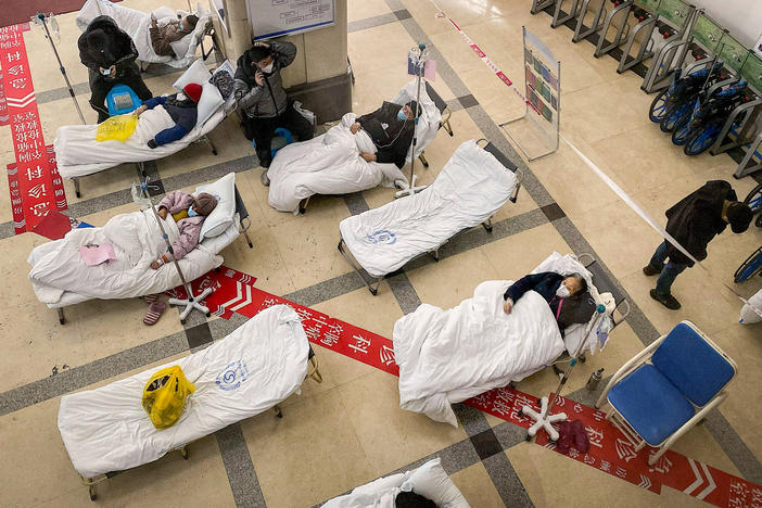 In some hospitals, like this one in Chongqing, one of China's largest cities, patients are lying on gurneys in the lobby because beds have run out.