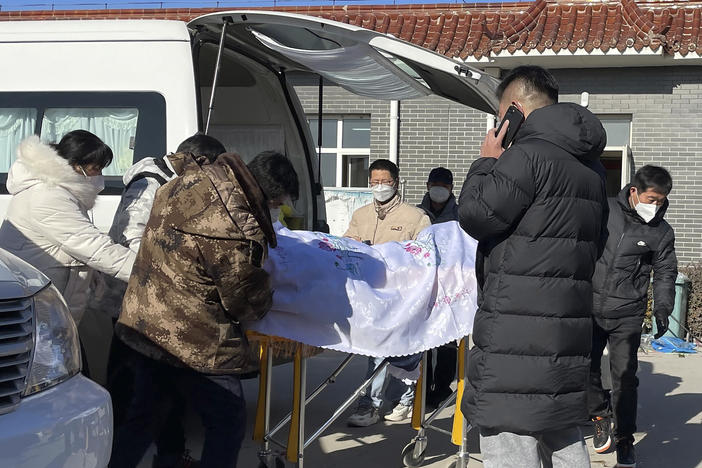 Liang from Beijing, center, looks on as his 82-year-old grandmother is brought in a casket to the Gaobeidian Funeral Home in northern China's Hebei province on Dec. 22, 2022. Liang's grandmother had been unvaccinated when she came down with coronavirus symptoms, and had spent her final days hooked to a respirator in a Beijing ICU.