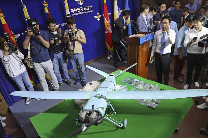 In this file photo from 2017, people view a suspected North Korean drone at South Korea's Defense Ministry in Seoul. The South Korean military fired warning shots and scrambled aircraft on Monday, saying that North Korean drones had entered their airspace.