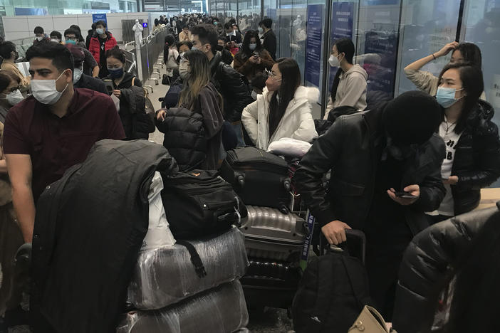 Inbound travelers wait for hours to board buses to leave for quarantine hotels and facilities from Guangzhou Baiyun Airport in southern China's Guangdong province on Dec. 25 2022.