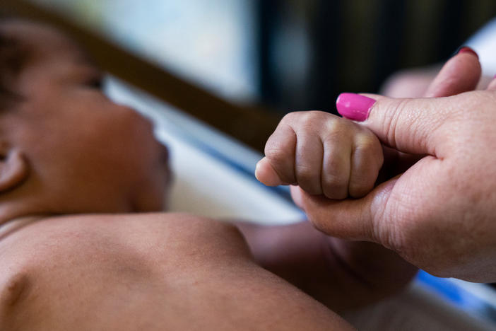 Registered nurse Carole Kriessman performs a quick checkup on Ja'Mil'Lion DeLorenzo's 4-week-old son, Haiyden, at DeLorenzo's grandmother's home in Glenolden, Pa., on June 9.