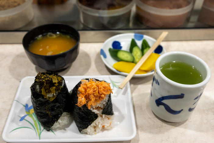 A lunch at Onigiri Bongo includes mustard green and salmon flake onigiri, miso soup, pickles and green tea.