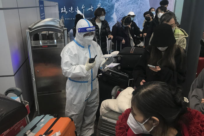 Inbound travelers wait for hours to board buses to leave for quarantine hotels and facilities from Guangzhou Baiyun Airport in southern China's Guangdong province on Dec. 25.