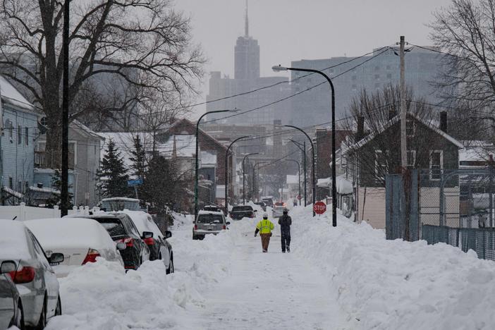 National Grid workers respond to a downed utility pole in Buffalo, N.Y., on Tuesday. The monster storm that killed dozens in the United States over the Christmas weekend continued to inflict misery on New York state and air travelers nationwide.