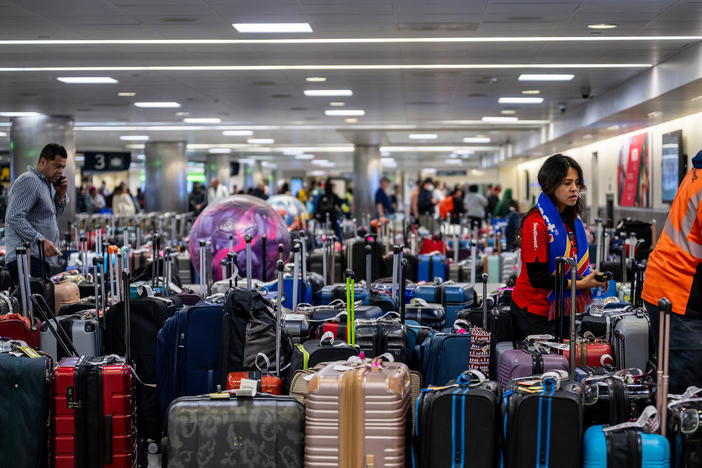 Airline staff search through unclaimed luggage at the William P. Hobby Airport on Wednesday in Houston.