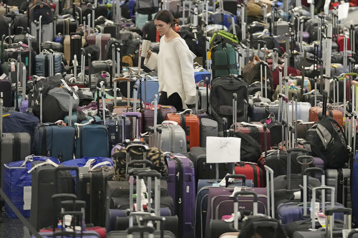 A woman walks through unclaimed bags at Southwest Airlines baggage claim at Salt Lake City International Airport on Thursday, as the carrier canceled another 2,350 flights after a winter storm overwhelmed its operations days ago.