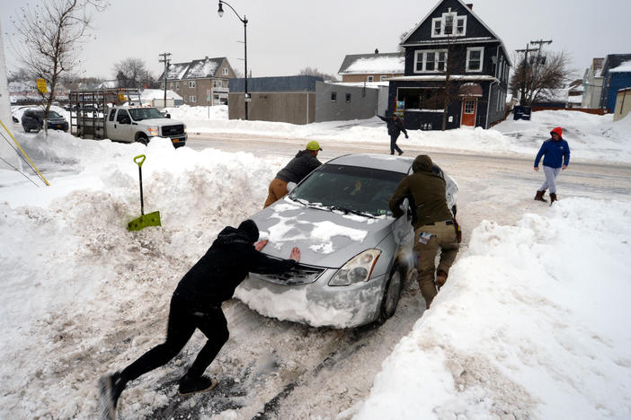 Good Samaritans help push out a car in Buffalo, N.Y., on Tuesday.