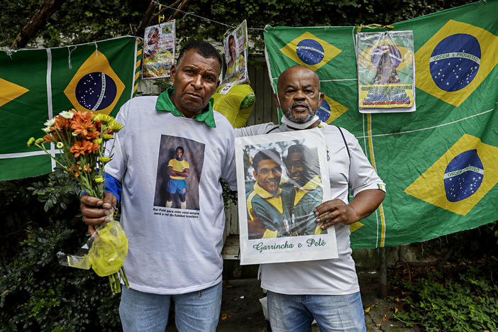 Antonio da Paz (left) and Renato Souza stand in front of the Albert Einstein Hospital holding memorabilia honoring Brazilian soccer star Pelé, in Sao Paulo on Friday.