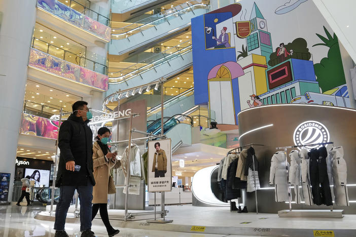 Shoppers walk through a reopened shopping mall after authorities started easing some of the anti-virus controls in Beijing on Dec. 6, 2022. Chinese manufacturing weakened for a third consecutive month in December, in the biggest drop since early 2020, as the country battles a nationwide COVID-19 surge after suddenly easing its anti-epidemic measures.