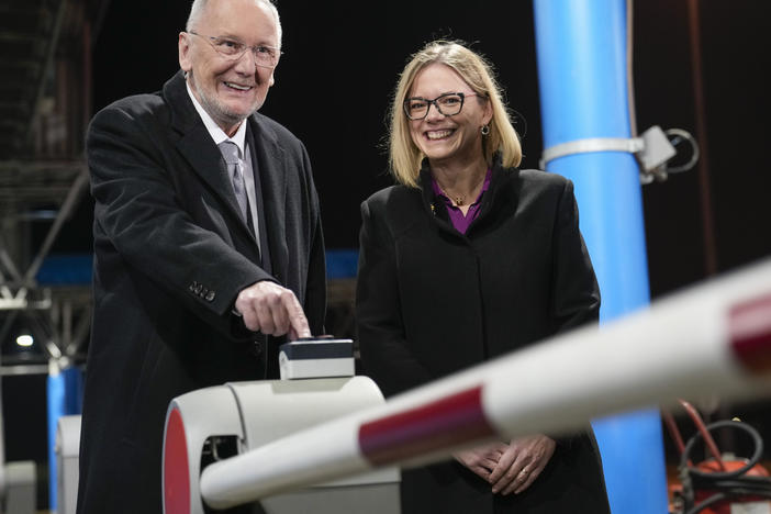 Croatia's Minister of Interior Davor Bozinovic, left, pushes a button to lift the barrier at the Bregana border crossing between Croatia and Slovenia, accompnanied by Slovenian counterpart Sanja Ajanovic Hovnik, early on Sunday.