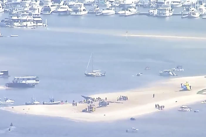 This image made from a video shows sand bank with crashed helicopter on Gold Coast, Australia Monday, Jan. 2, 2023. Two helicopters collided Monday afternoon over the Australian beach. (Australian Broadcasting Corp. via AP)