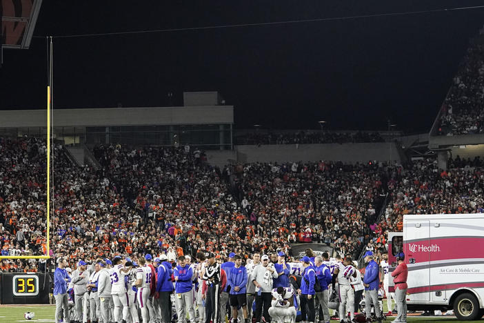 Buffalo Bills players pray for teammate Damar Hamlin after he collapsed during the first half of their NFL game against the Cincinnati Bengals Monday night. The game has been postponed indefinitely, NFL Commissioner Roger Goodell announced.