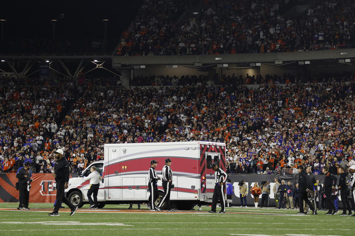 Fans watch as Buffalo Bills football player Damar Hamlin leaves Cincinnati's Paycor Stadium in an ambulance on Monday night after experiencing a cardiac arrest during a game.