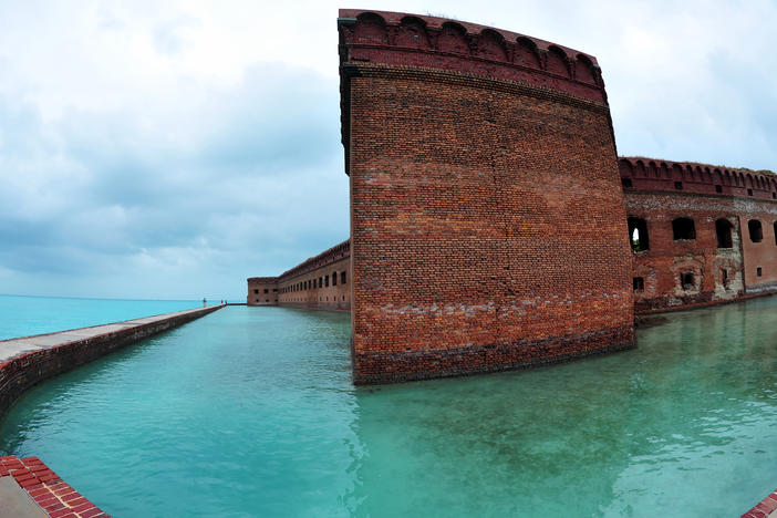 Over the holiday weekend, hundreds of migrants landed in Dry Tortugas National Park, about 70 miles west of Key West, Fla., in the Gulf of Mexico. Tourists walk along the sea wall surrounding Fort Jefferson in the park in February 2016.