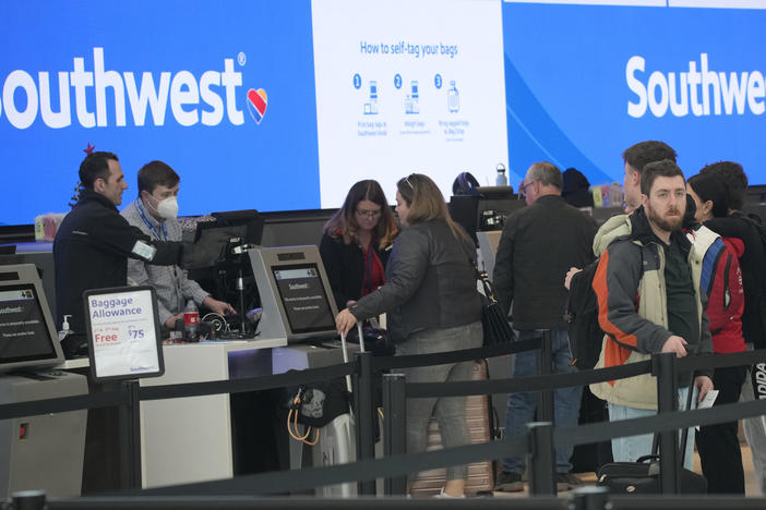 Travelers are shown lining up at the check-in counters for Southwest Airlines in Denver International Airport, Friday, Dec. 30, 2022, in Denver.