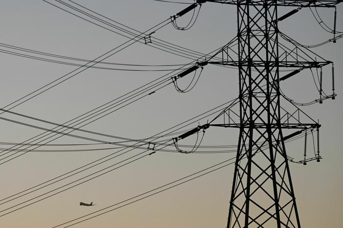 Electric power lines are displayed at sunset in El Segundo, Calif., on Aug. 31, 2022. The FBI charged two men over attacks on Washington state's power grid that left thousands without power.