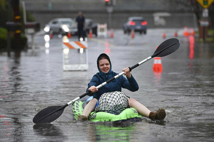 Nurse Katie Leonard uses a kayak to bring supplies to Patsy Costello, 88, as she sits trapped in her vehicle Dec. 31 on Astrid Drive in Pleasant Hill, Calif.. Costello drove her car on the flooded street thinking she could make it, but it stalled in the two feet of water.