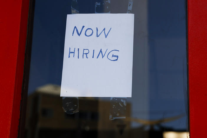 A "Now Hiring" sign is displayed on a storefront in the Adams Morgan heighborhood in Washington, D.C., on Oct. 07, 2022 .