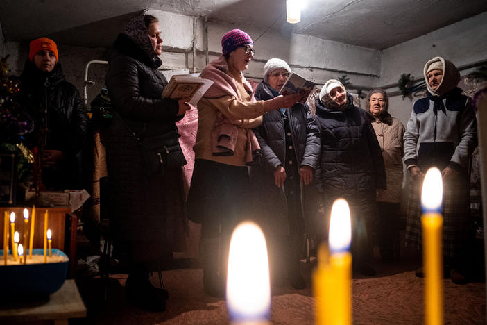 Worshipers pray during an Orthodox Christmas mass in a basement shelter in Chasiv Yar, eastern Ukraine, on Jan. 7. As artillery boomed outside and fighter jets flew overhead, Orthodox Christians in a battered eastern Ukraine town held a Christmas service in a basement shelter vowing, not to let war ruin the holiday.