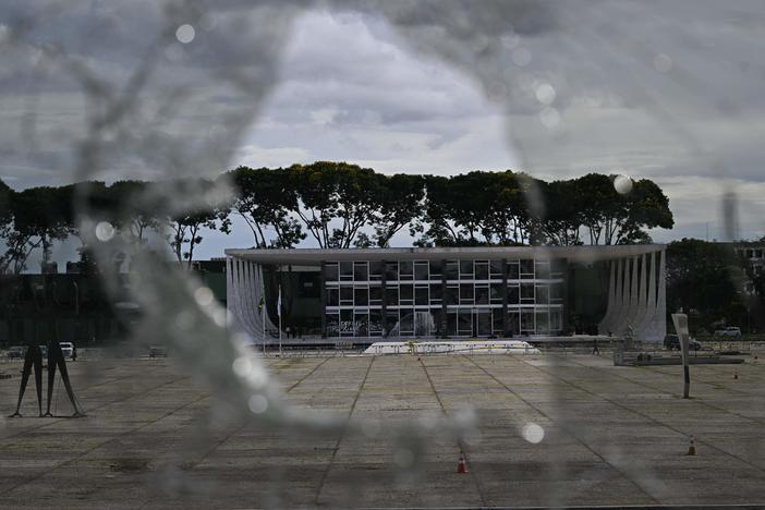 Brazil's Supreme Court building is seen through a broken window of the Planalto presidential building in Brasília on Monday, a day after supporters of Brazil's far-right ex-president, Jair Bolsonaro, invaded the Congress, presidential palace and Supreme Court.