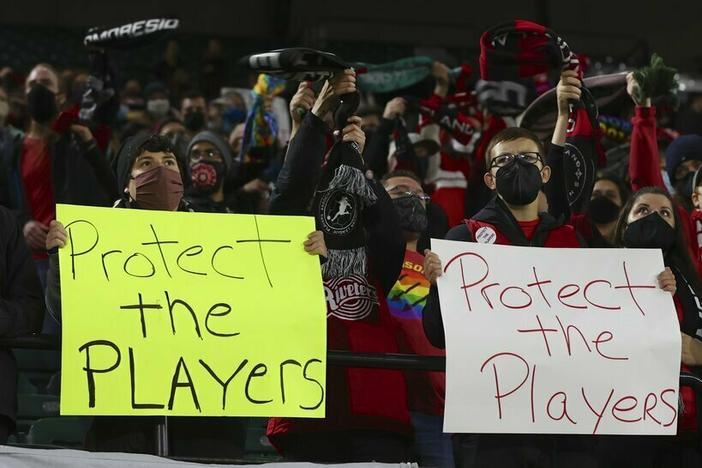 Portland Thorns fans hold signs in October 2021 during the first half of the team's National Women's Soccer League soccer match against the Houston Dash in Portland, Ore.