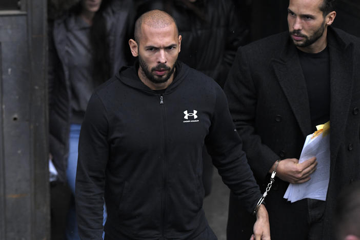 Andrew Tate (center) and his brother Tristan leave after appearing at the Court of Appeal, in Bucharest, Romania, on Tuesday.