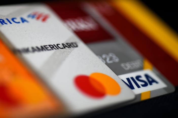 This illustration picture shows debit and credit cards arranged on a desk on April 6, 2020 in Arlington, Va. Americans are using their credit cards more to pay for everyday expenses at a time when interest rates are rising.