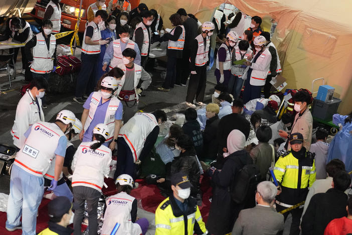 Rescue workers treat injured people on the street near the scene of a crowd surge in Seoul, South Korea, on Oct. 30, 2022. South Korean police on Friday, Jan. 13, 2023, said they are seeking charges of involuntary manslaughter and negligence against 23 officials.