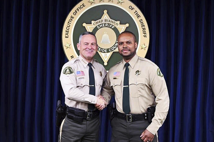 Riverside County Deputy Darnell Calhoun (right) poses with Sheriff Chad Biano in an undated photo. Calhoun was shot and killed Friday, just two weeks after another deputy in the department was slain in the line of duty.