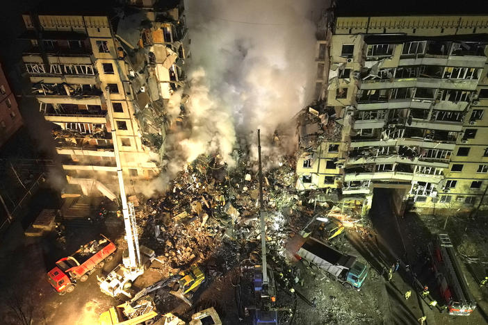 Emergency workers clear the rubble after a Russian rocket hit a multistory building leaving many people under debris in the southeastern city of Dnipro, Ukraine, on Jan. 14, 2023.