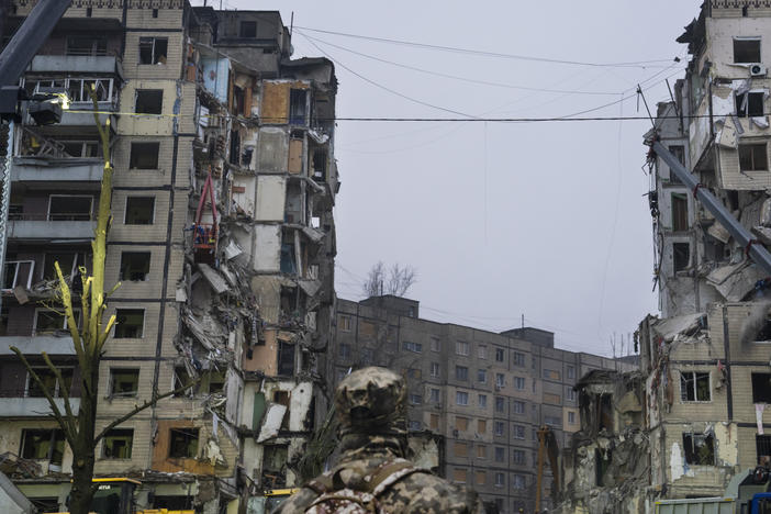 A soldier stares up at a gaping hole in an apartment building in Dnipro, Ukraine on Monday. The city was hit by Russian missiles on Saturday.